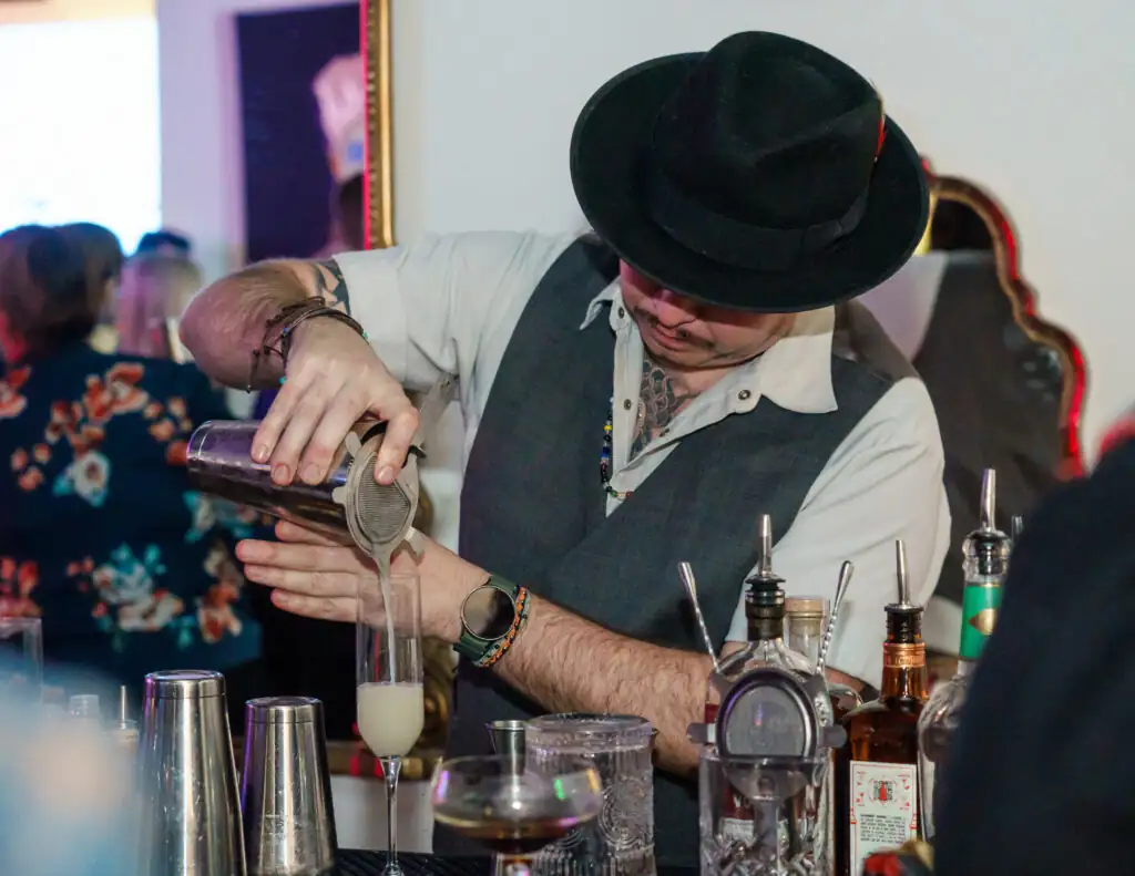 Mixologist pouring a drink into glass at Dave Cantin Group's NADA Afterparty in New Orleans 2025