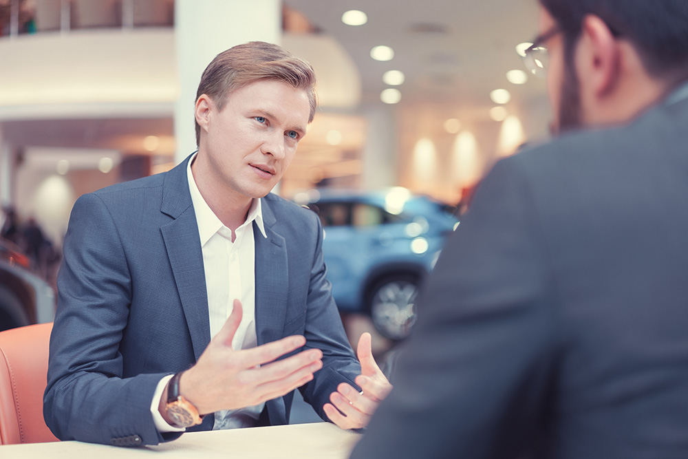 2 men discussing at dealership